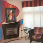 the fireplace surround is painted to match the furniture and the colors used on the wall help to focus on the painting